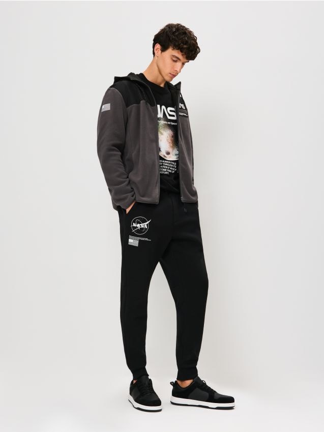 Sinsay - Nohavice tapered fit NASA - čierna Sinsay - Nohavice tapered fit NASA - čierna