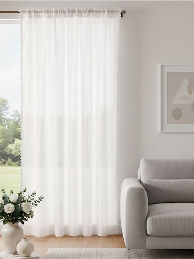 Ühevärviline kardin rõngastega ja pompomidega