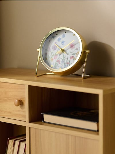 Namizna ura v zlatem okvirju s cvetličnim motivom