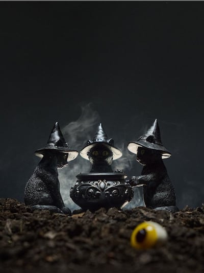 Halloweeni küünlaalus teeküünlale kasside ja katla kujul