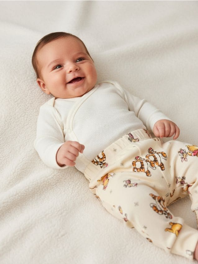 Sinsay - Nohavice s flísom vo vnútri s vianočným motívom Winnie the Pooh - krémová